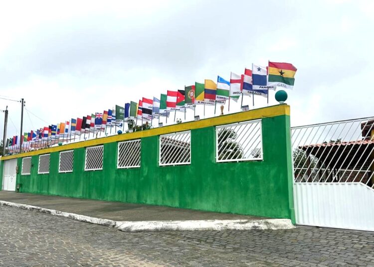 Aposentado mantém tradição e amplia muro de chácara com bandeiras de países participantes da Copa do Mundo