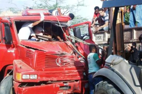 Caminhoneiro fica preso nas ferragens ao colidir com  caçamba