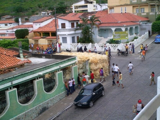 Caminhão carregado de sisal tomba sobre uma casa