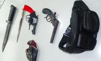 Pochete da vítima e o revolver usado no duplo homicídio (detalhe em vermelho)