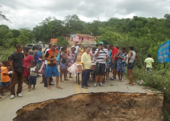 Saúde: moradores ironizam levando bolo para comemorar um ano de abertura de cratera na pista que permanece do mesmo jeito