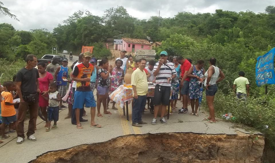 Saúde: moradores ironizam levando bolo para comemorar um ano de abertura de cratera na pista que permanece do mesmo jeito