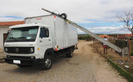 Caminhão atinge fiação e poste cai sobre baú