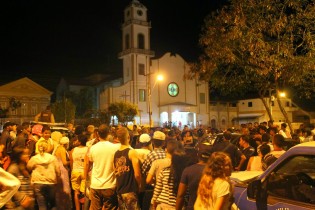 Populares lotam a praça e ao fundo a Catedral no momento da missa.