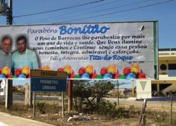 Irreverente, vice governador parabeniza vice prefeito de Barrocas em outdoor o chamando de “Bonitão”