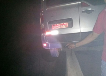 Van que transportava banda perde controle e fica pendurada em mureta de ponte