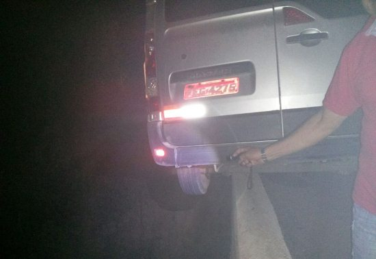 Van que transportava banda perde controle e fica pendurada em mureta de ponte