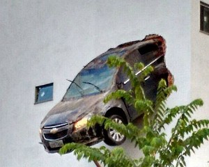 ES: Motorista erra freio e carro fica pendurado a 15 metros em parede de garagem