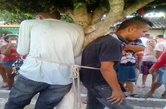 Dois homens suspeitos de praticarem assalto são detidos por populares e amarrados em árvore