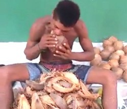 Homem ganha a vida descascando cocos com dentes
