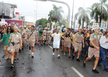 Debaixo de chuva Tocha Olímpica percorre avenidas de Feira de Santana