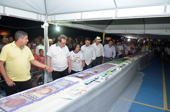 Lideranças olham cada foto sobre o bolo que conta a evolução de Nordestina e seus primeiros moradores