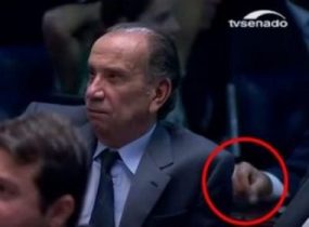 parlamentar balançando um pacote com pó branco dentro