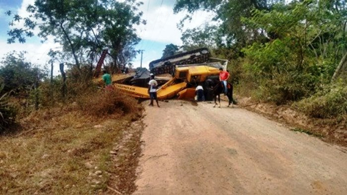 Caminhão carregado com escavadeira tomba após não conseguir subir ladeira
