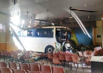 Ônibus desgovernado atinge dois carros e só parou quando invadiu o auditório de uma escola