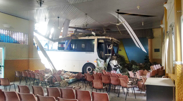 Ônibus desgovernado atinge dois carros e só parou quando invadiu o auditório de uma escola