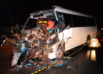 Micro-ônibus bate em carreta parada em acostamento e deixa seis feridos; frente do veículo fica destruída