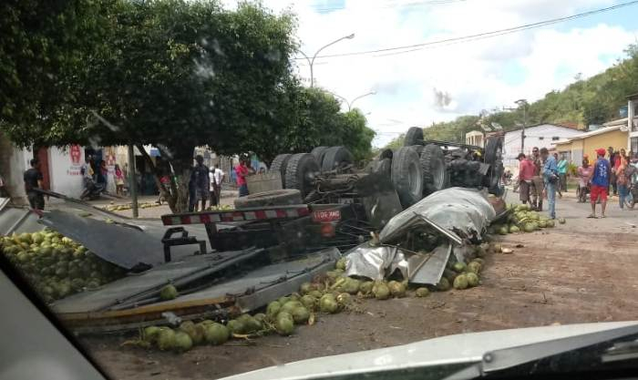 Caminhão baú carregado de coco capota e deixa dois feridos