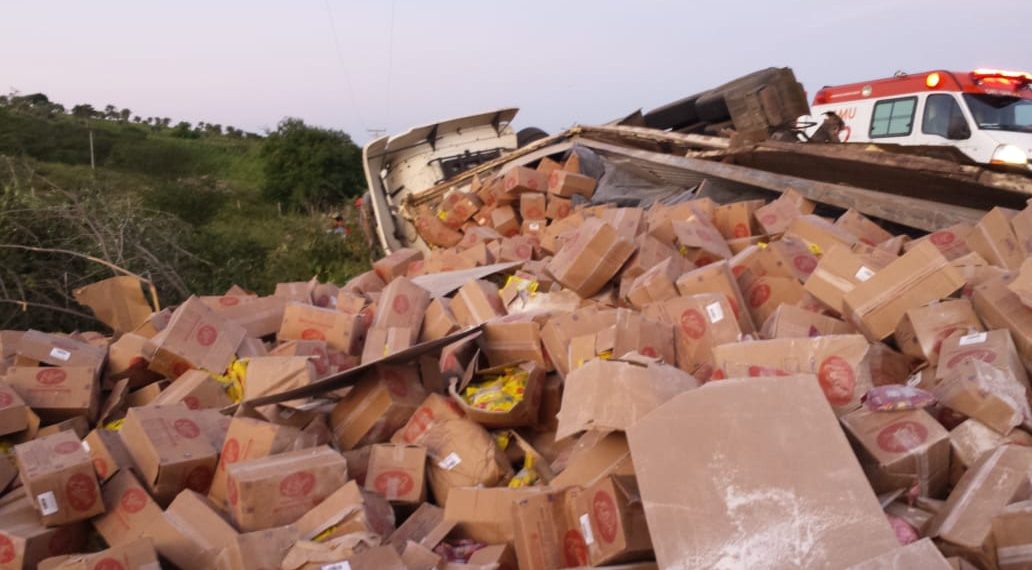 Caminhão carregado de balas capota na BA 130 e condutor morre