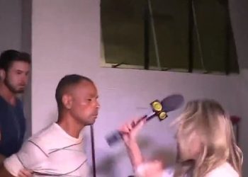 SP – Suspeito de homicídio cospe em repórter da Band quando deixava delegacia e ela reage com microfone na cara dele