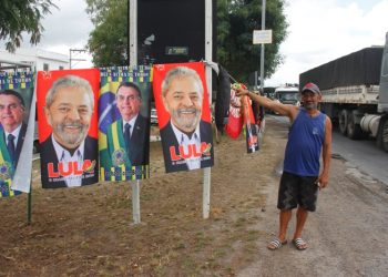 Vendedor de rede fatura com venda de toalha com a imagem de Lula e Bolsonaro