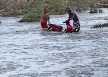 Homens lutam muito para evitar que moto fosse levada pelas águas de um rio (vídeos)