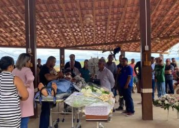 Deitada em maca, sobrevivente do acidente que matou 25 pessoas acompanha velório da filha